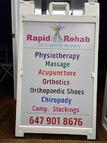 Sidewalk sign listing physiotherapy, massage, acupuncture, orthotics, orthopaedic shoes, chiropody and compression stockings